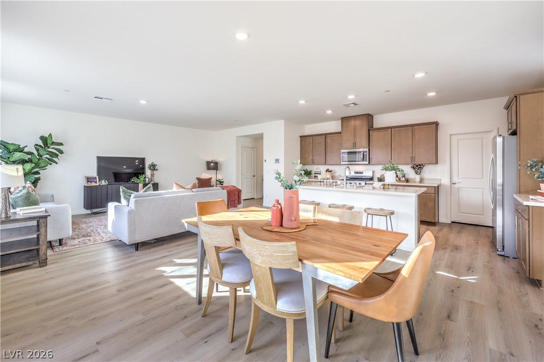 568 Ivory Peacock Ct, Henderson, NV 89011 Smooth wood flooring flows seamlessly through this open-concept layout connecting dining, kitchen, and living areas.