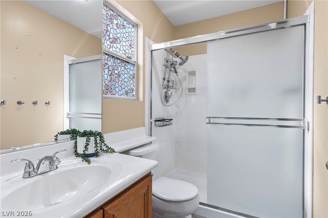 688 Canfield Point Avenue, Las Vegas, NV 89183 Frosted glass sliding doors enclose the walk-in shower in this functional bathroom space.