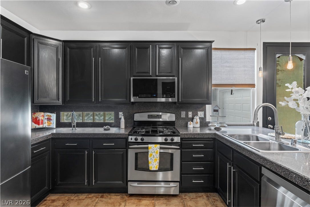 688 Canfield Point Avenue, Las Vegas, NV 89183 Striking dark cabinetry and durable stone counters define this fully equipped culinary workspace.
