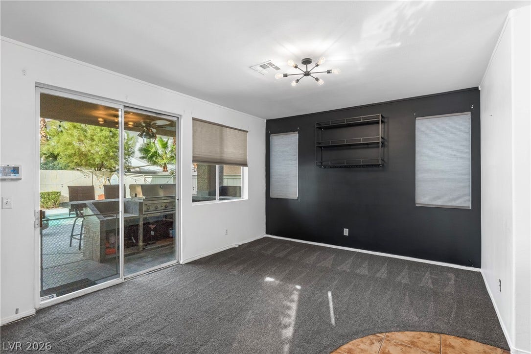688 Canfield Point Avenue, Las Vegas, NV 89183 Sliding glass doors open from this carpeted living area to the outdoor patio.