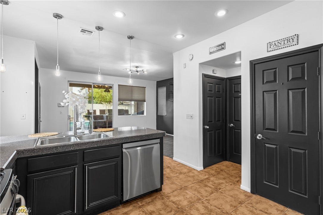 688 Canfield Point Avenue, Las Vegas, NV 89183 Gleaming tile floors and modern recessed lighting enhance this functional kitchen workspace.
