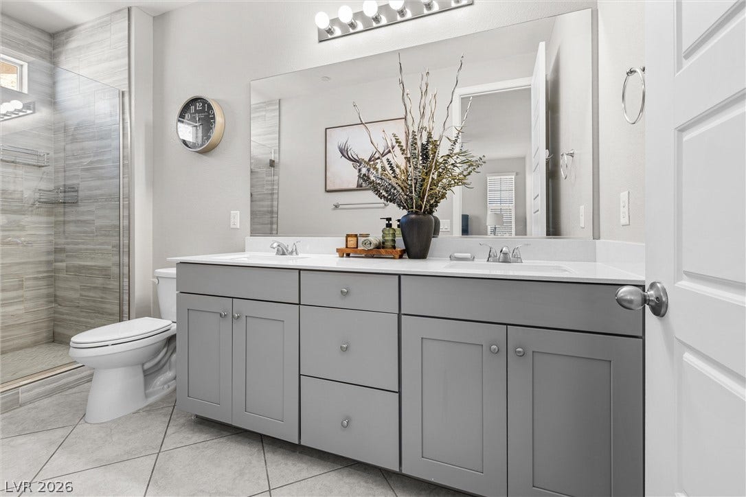 44 Kimberlite Drive, Henderson, NV 89011 This upgraded bathroom features a double vanity and a glass-enclosed shower, offering modern comfort.