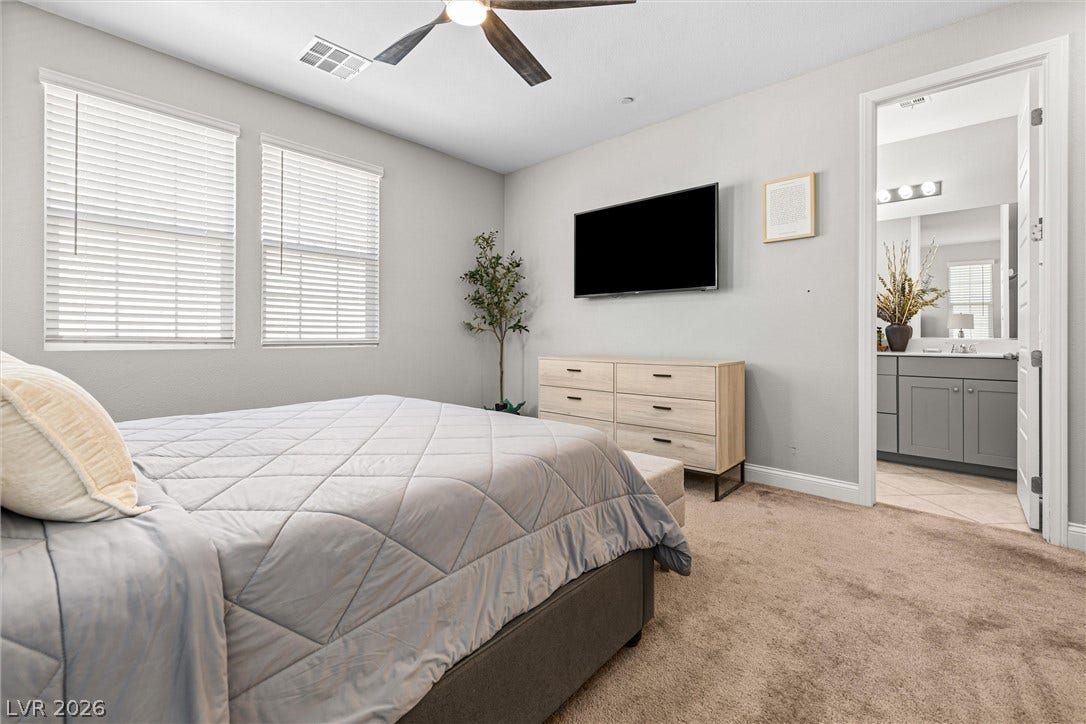 44 Kimberlite Drive, Henderson, NV 89011 This restful bedroom features soft carpet flooring, bright windows, and convenient access to a private bath.
