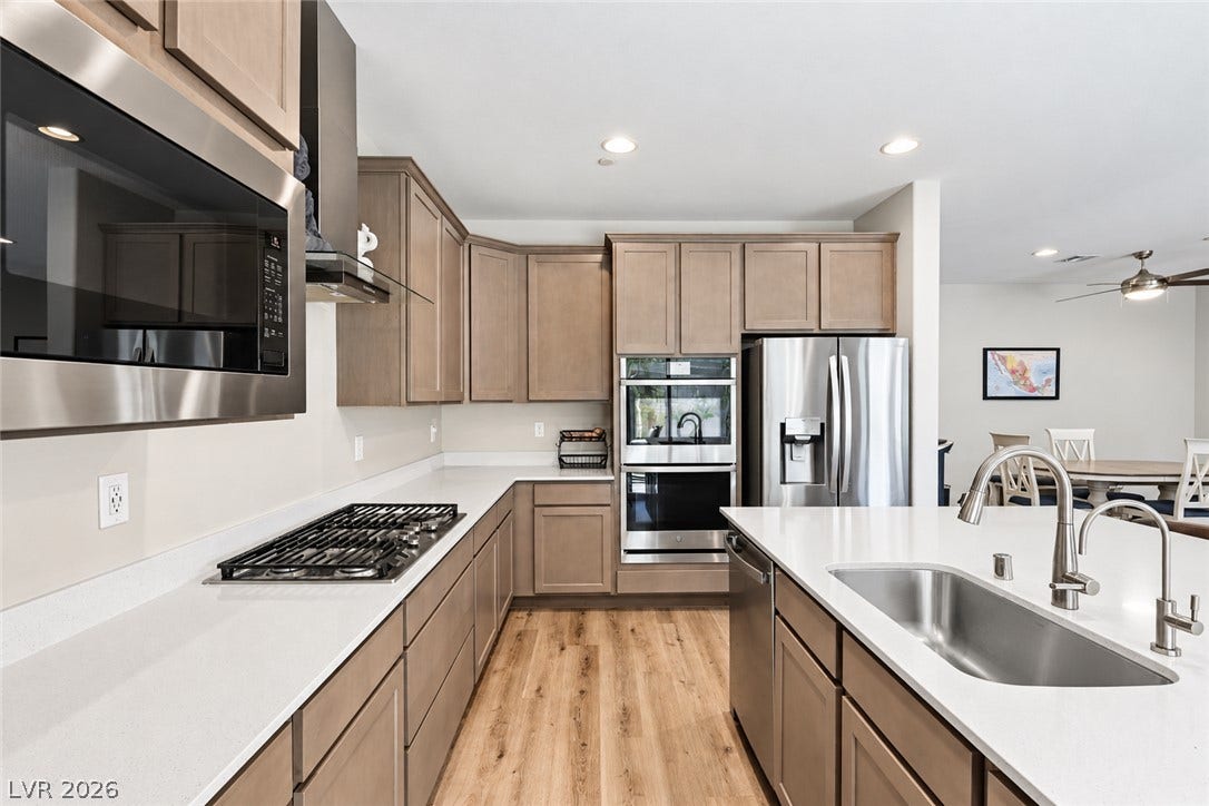 31 Cresta Villa Court, Henderson, NV 89011 Gleaming stone countertops and stainless steel appliances anchor this modern cooking space.