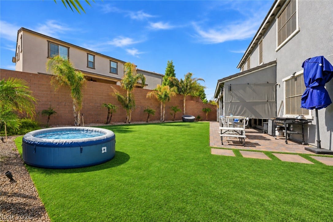 31 Cresta Villa Court, Henderson, NV 89011 Manicured green lawn and a brick patio create a private backyard retreat.