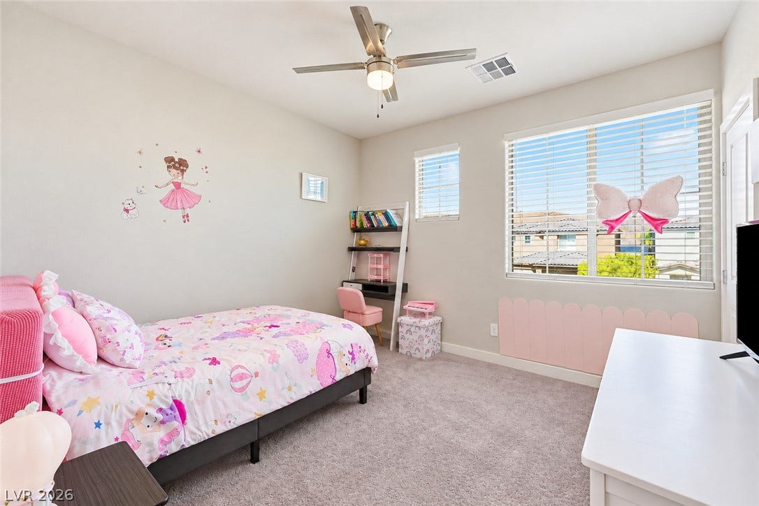 31 Cresta Villa Court, Henderson, NV 89011 A well-lit bedroom features plush carpeting and multiple windows offering views of the neighborhood.