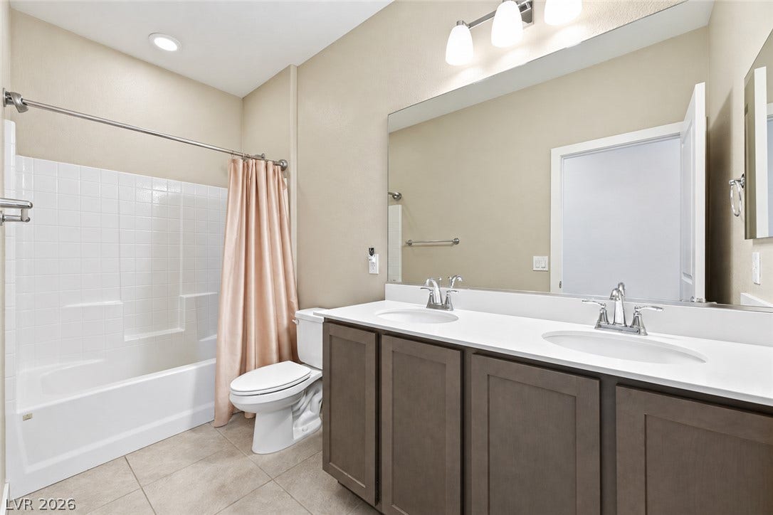 31 Cresta Villa Court, Henderson, NV 89011 Double vanity sinks and clean tile flooring define this updated guest bathroom.