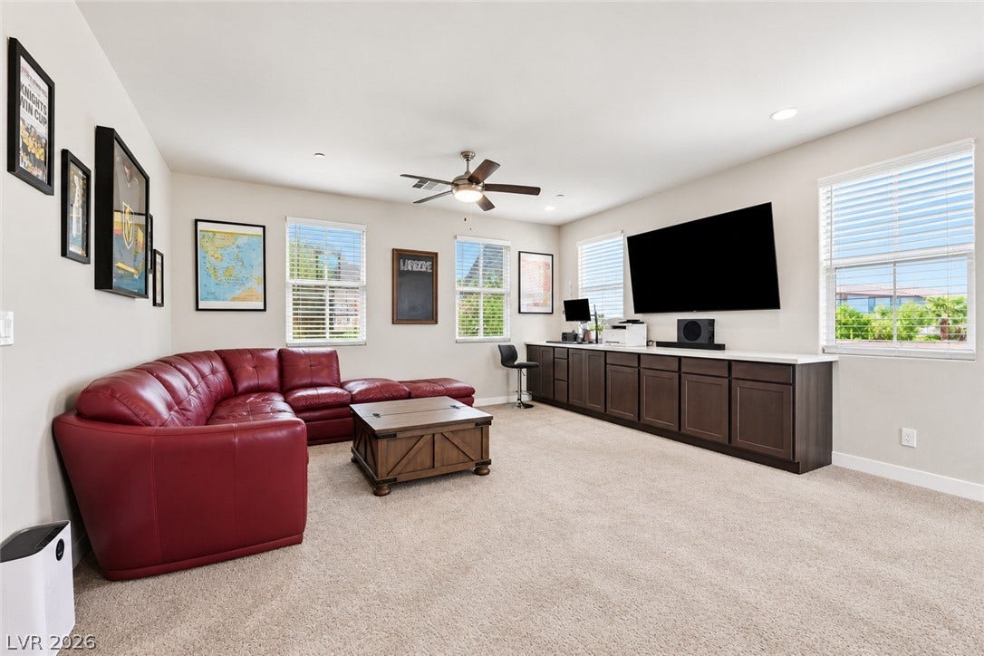 31 Cresta Villa Court, Henderson, NV 89011 A spacious media room features built-in cabinetry, wall-mounted television wiring, and plush carpeting.