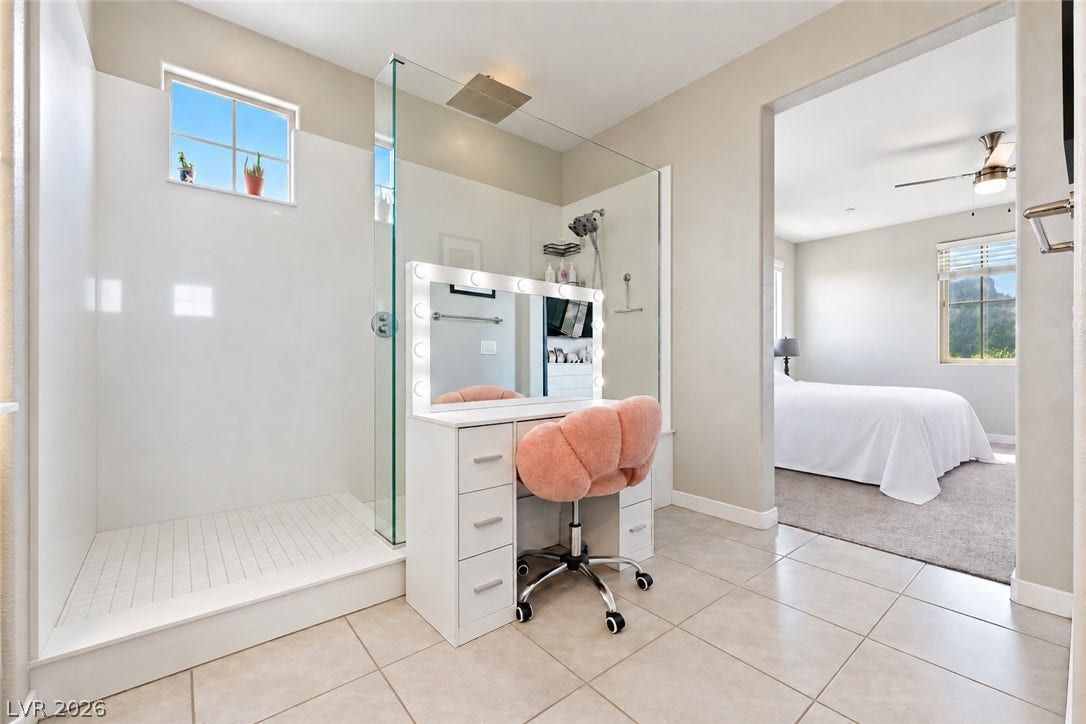 31 Cresta Villa Court, Henderson, NV 89011 A glass-enclosed shower and tiled flooring highlight this modern primary bathroom suite.