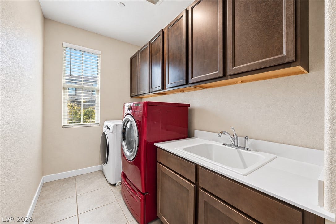 31 Cresta Villa Court, Henderson, NV 89011 A functional laundry area boasts tile flooring, built-in cabinetry, and a utility sink.