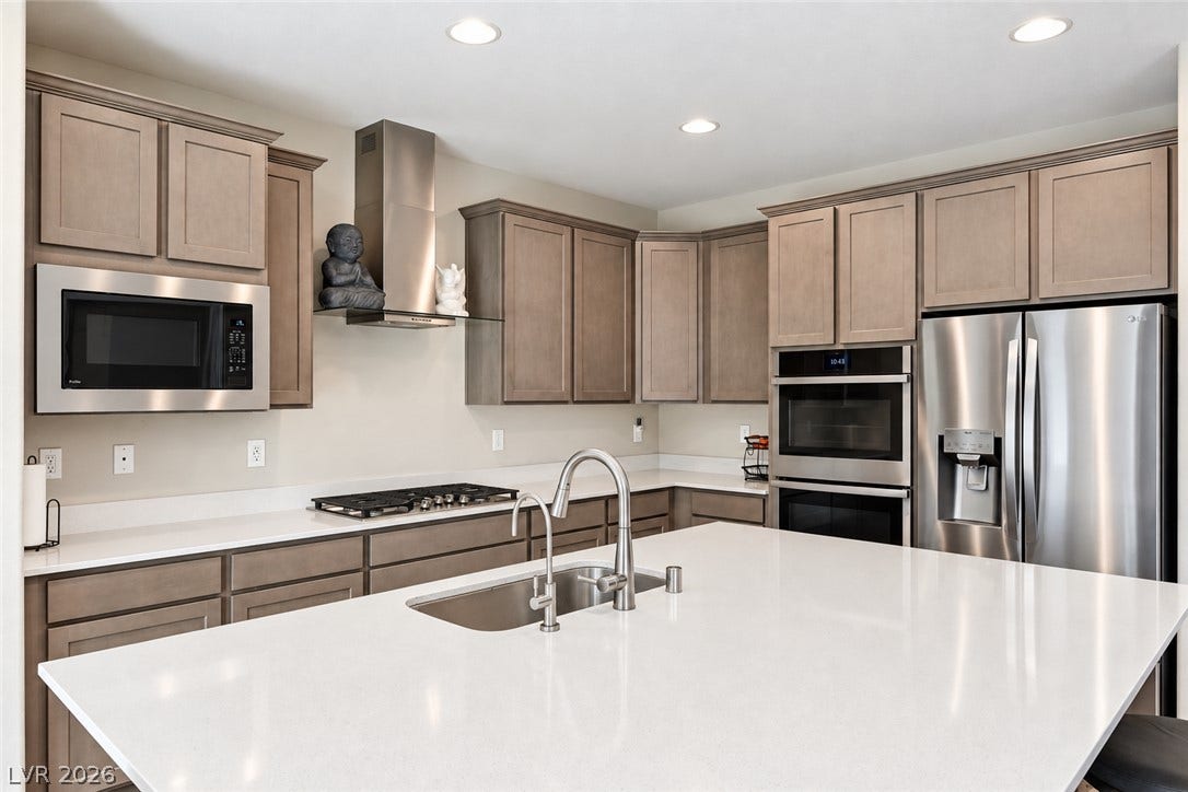 31 Cresta Villa Court, Henderson, NV 89011 A spacious central island with quartz countertops anchors this contemporary cooking space.