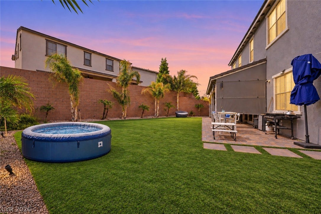 31 Cresta Villa Court, Henderson, NV 89011 Manicured green lawn and a spacious paved patio border the rear of the home.