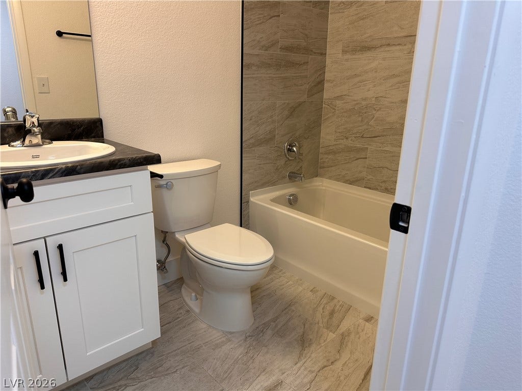 230 Mission Catalina Lane, #107, Las Vegas, NV 89107 Tiled flooring and a coordinating tub surround elevate this clean, modern bathroom space.