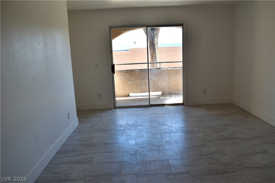 230 Mission Catalina Lane, #107, Las Vegas, NV 89107 Sliding glass doors open directly to a private balcony from this tiled living space.