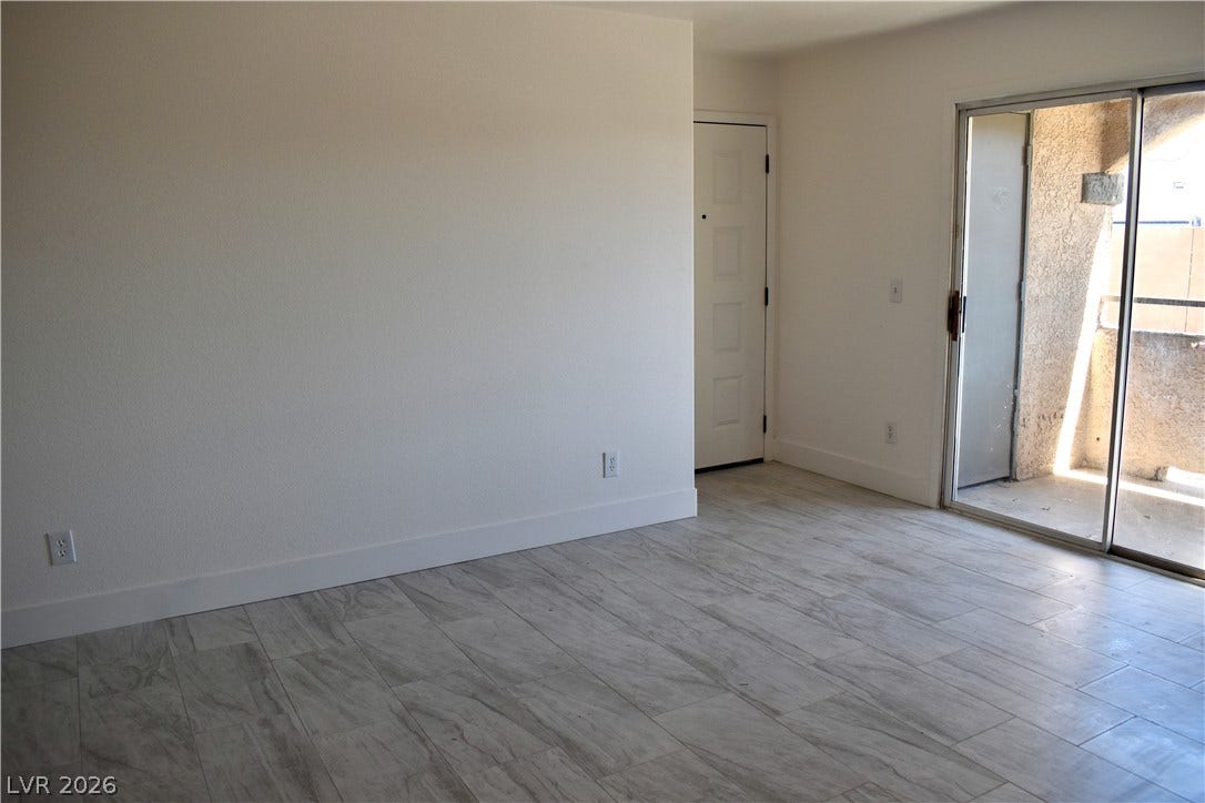 230 Mission Catalina Lane, #107, Las Vegas, NV 89107 Sliding glass doors open directly to a private balcony from this tiled living space.