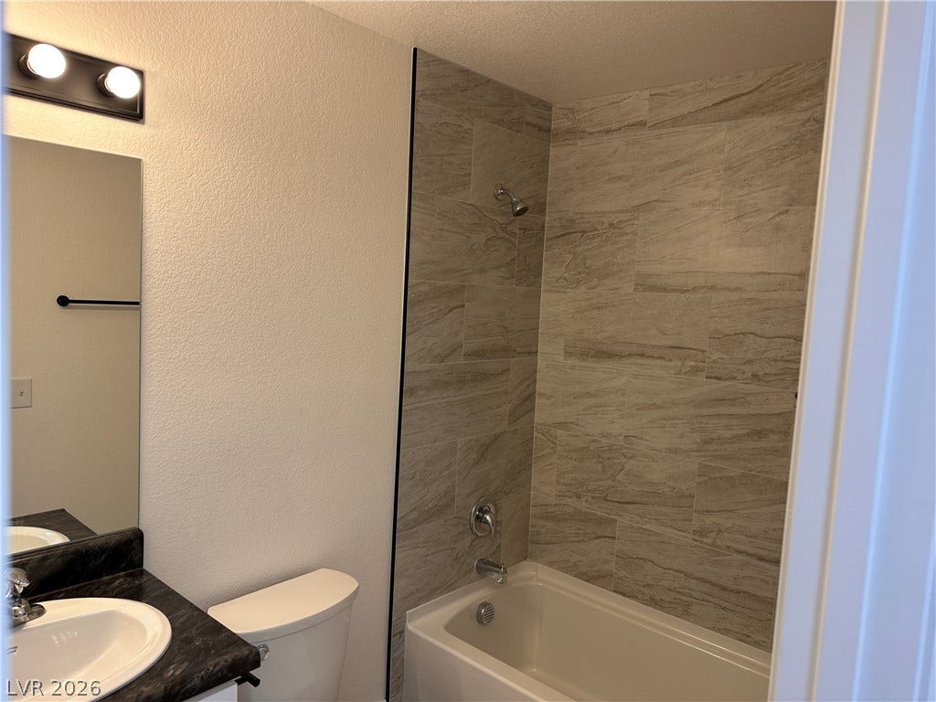 230 Mission Catalina Lane, #107, Las Vegas, NV 89107 A modern bathroom features a tiled shower surround alongside a dark vanity top.