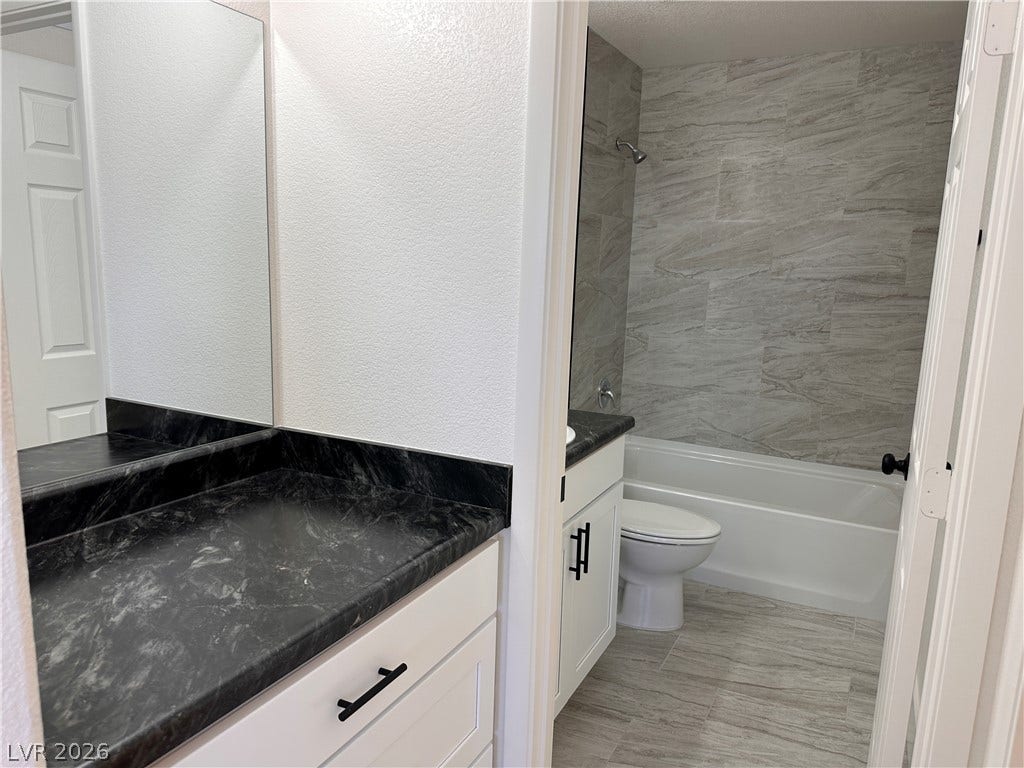 230 Mission Catalina Lane, #107, Las Vegas, NV 89107 Granite counters and tiled shower walls elevate this modern split-layout bathroom design.
