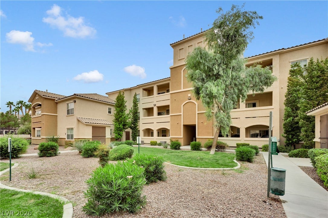 8777 W Maule Avenue, #2109, Las Vegas, NV 89148 Multi-level Mediterranean-inspired architecture frames a landscaped courtyard under blue skies.