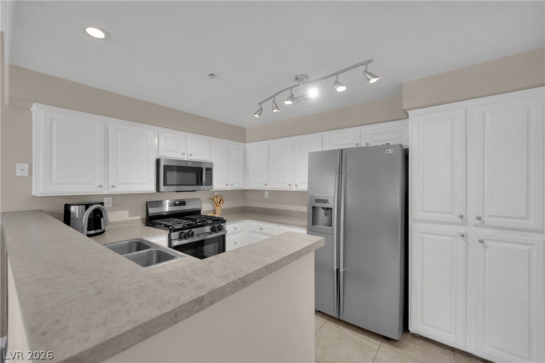 8777 W Maule Avenue, #2109, Las Vegas, NV 89148 Bright white cabinetry and stone-look countertops define this functional, modern kitchen workspace.