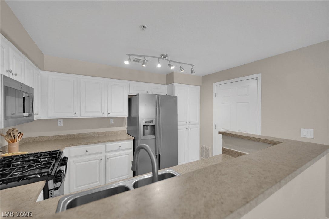 8777 W Maule Avenue, #2109, Las Vegas, NV 89148 Crisp white cabinetry pairs beautifully with stone countertops in this functional kitchen layout.