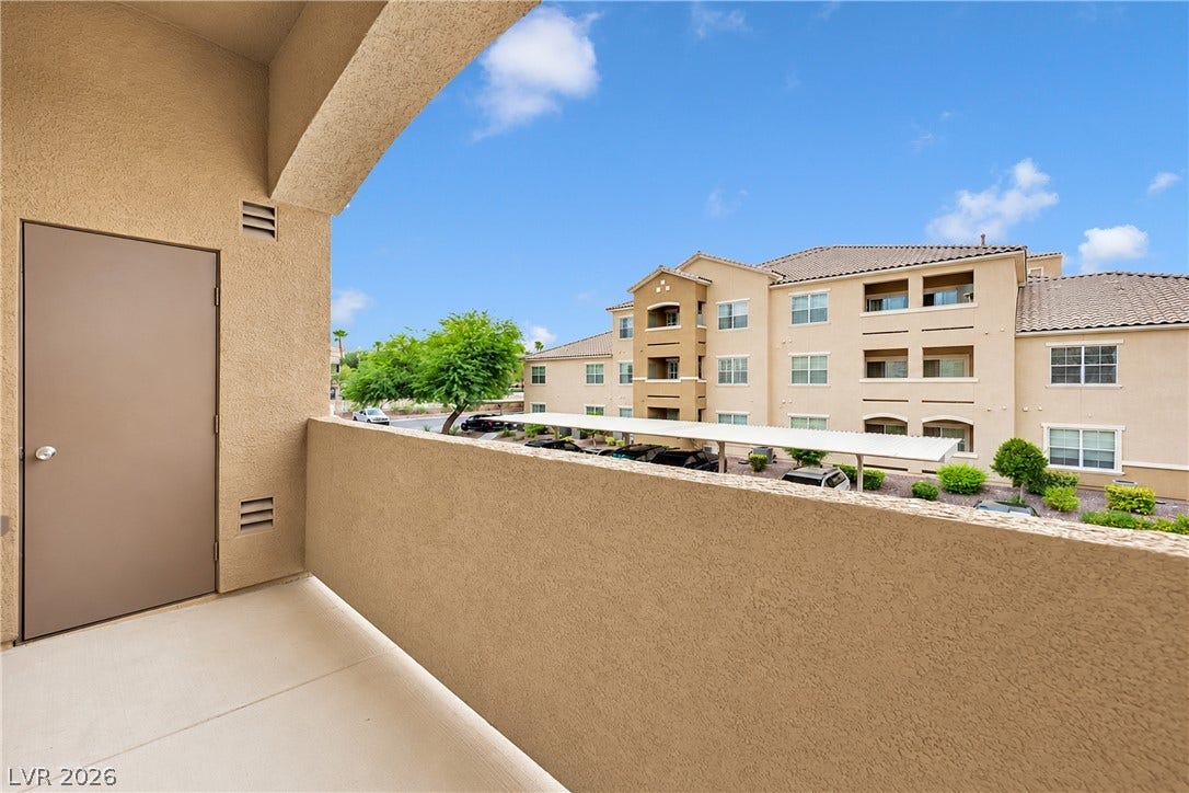 8777 W Maule Avenue, #2109, Las Vegas, NV 89148 A private covered balcony features smooth concrete flooring and stucco walls overlooking neighborhood views.