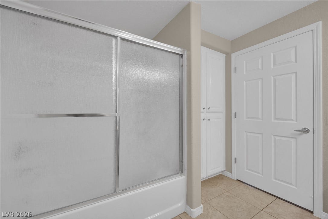 8777 W Maule Avenue, #2109, Las Vegas, NV 89148 Tiled flooring runs throughout this bathroom area featuring built-in cabinetry and a tub shower setup.