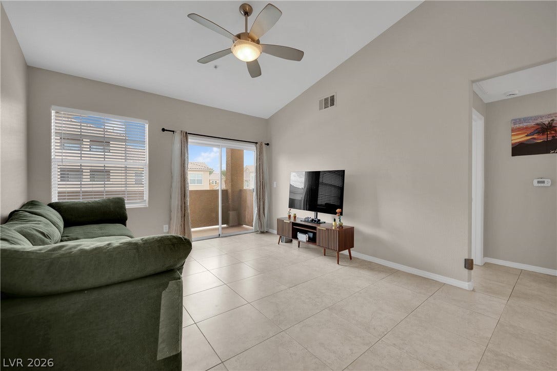 8777 W Maule Avenue, #2109, Las Vegas, NV 89148 A vaulted ceiling and tile floors define this airy living room opening to the balcony.