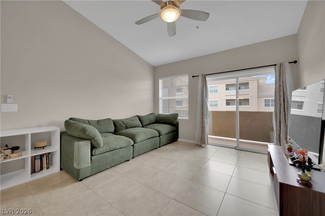 8777 W Maule Avenue, #2109, Las Vegas, NV 89148 High vaulted ceilings and tile flooring enhance this welcoming living room opening to a balcony.