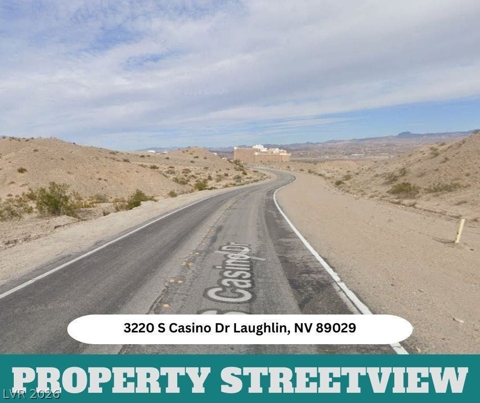 3220 Casino Dr, Laughlin, NV 89029 Desert hills frame a winding asphalt road leading toward the distant horizon.