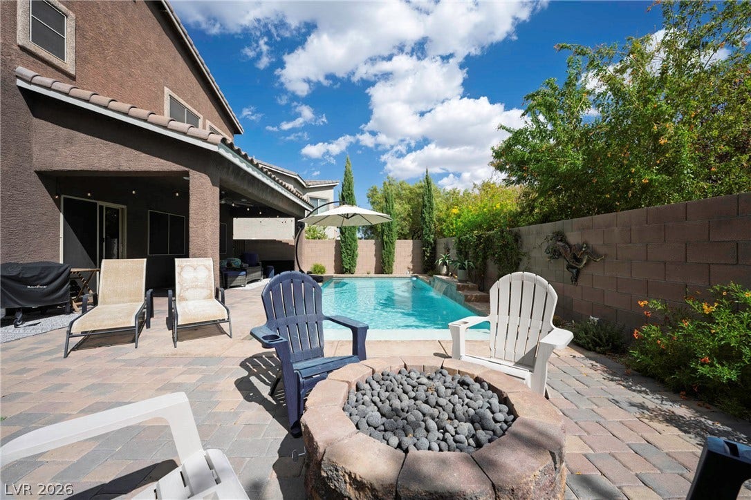 152 Dunblane Street, Henderson, NV 89012 An inviting stone fire pit overlooks a sparkling pool flanked by brick pavers.