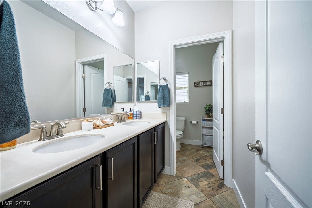 152 Dunblane Street, Henderson, NV 89012 Stone counters and custom tile flooring elevate this dual-sink vanity space.