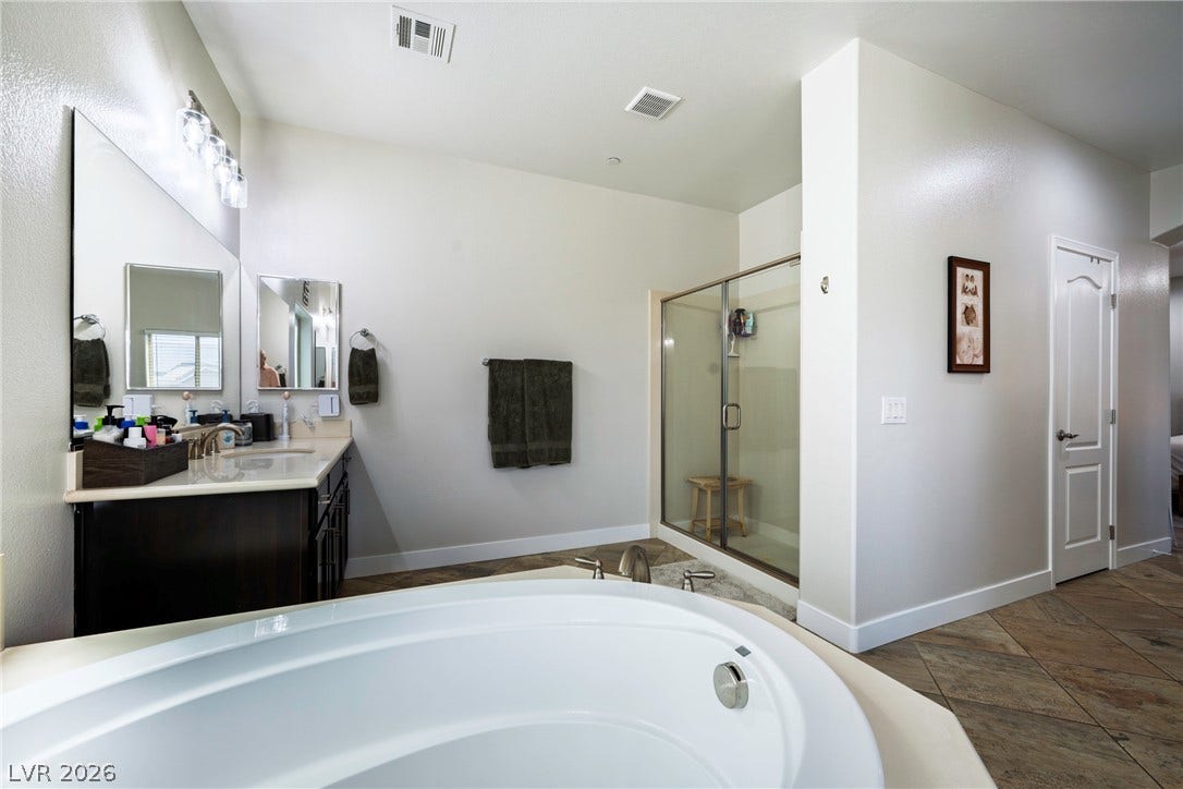152 Dunblane Street, Henderson, NV 89012 A spacious layout highlights the tiled flooring and separate soaking tub with a walk-in shower.