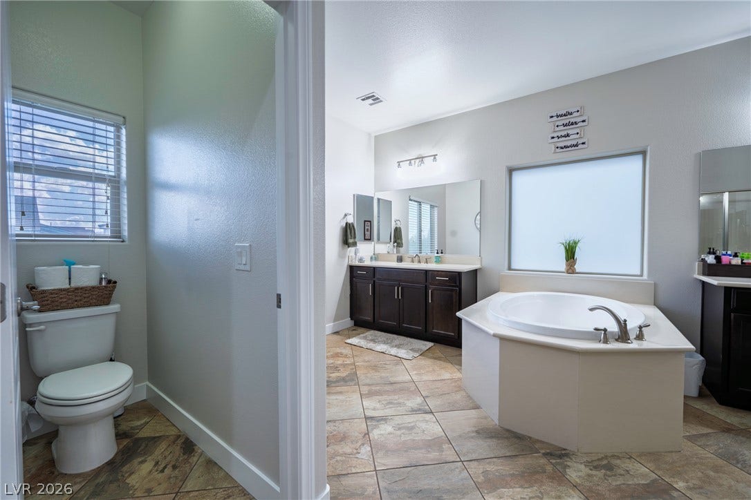 152 Dunblane Street, Henderson, NV 89012 A spacious soaking tub and dual vanities anchor this beautifully tiled primary bathroom.