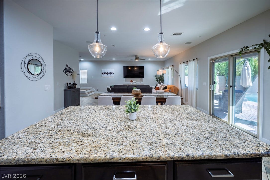 152 Dunblane Street, Henderson, NV 89012 Granite-topped counters anchor a spacious open-concept interior overlooking the outdoor pool area.
