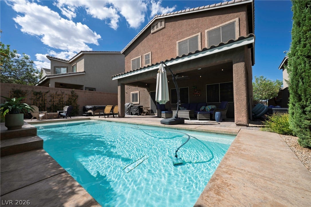 152 Dunblane Street, Henderson, NV 89012 An inviting backyard swimming pool borders a spacious covered patio beneath sunny desert skies.