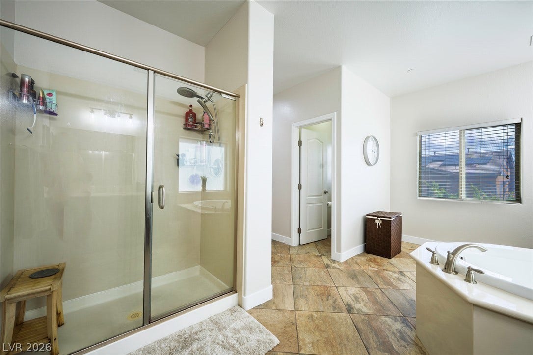 152 Dunblane Street, Henderson, NV 89012 Tiled flooring runs throughout this bathroom complete with a glass-enclosed shower and soaking tub.