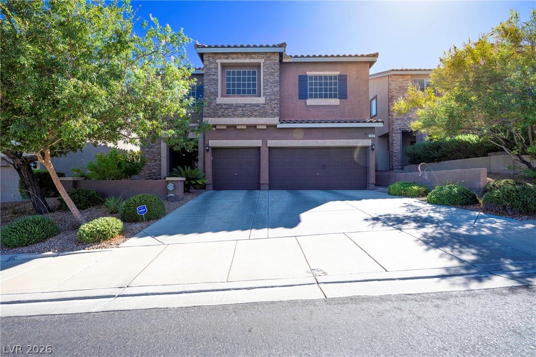 152 Dunblane Street, Henderson, NV 89012 An inviting stone and stucco facade frames the expansive concrete driveway and multi-car garage.
