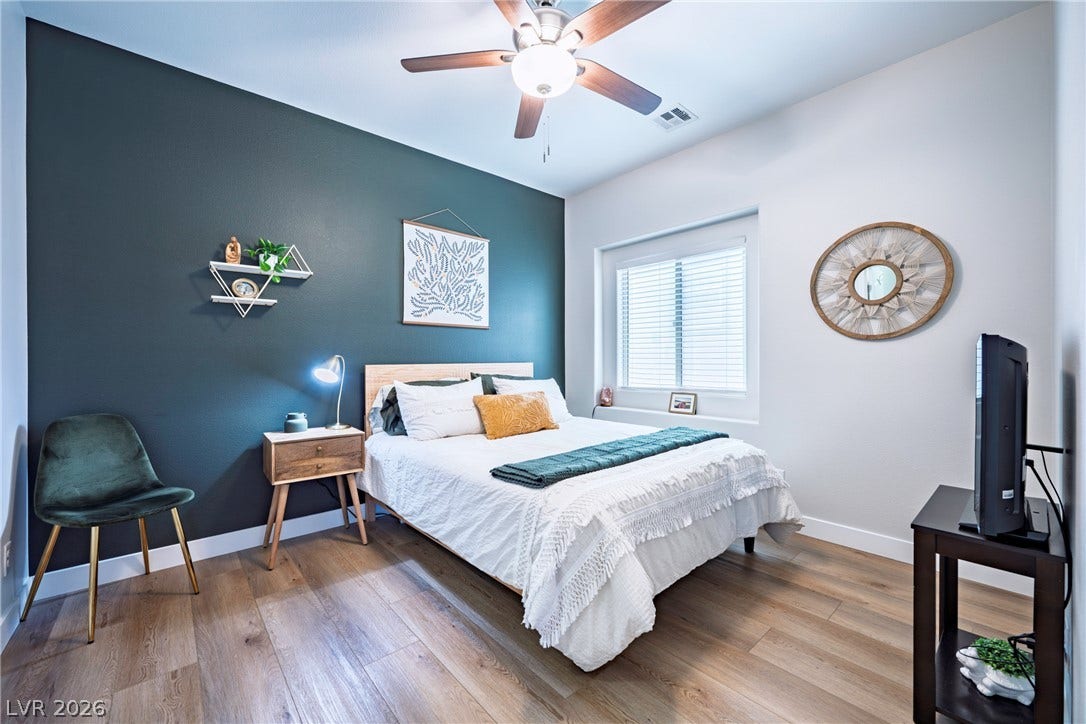 152 Dunblane Street, Henderson, NV 89012 Warm wood flooring and natural light elevate this welcoming bedroom space.