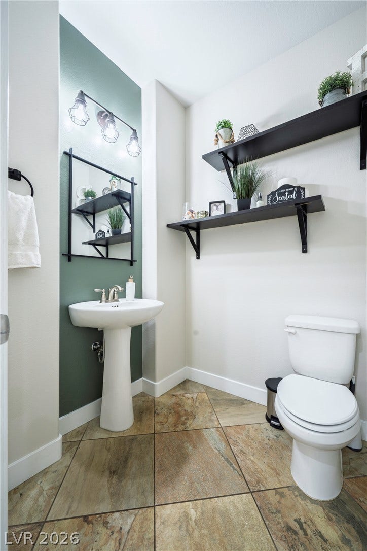 152 Dunblane Street, Henderson, NV 89012 Textured tile flooring pairs beautifully with a classic pedestal sink in this modern powder room.