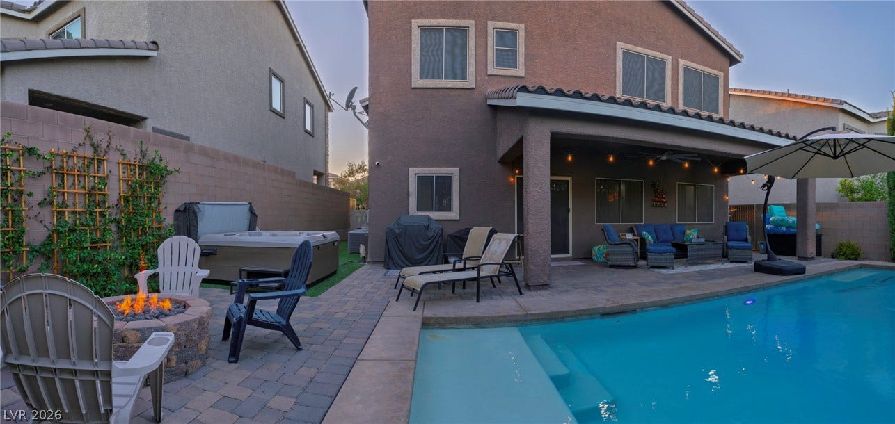 152 Dunblane Street, Henderson, NV 89012 An inviting backyard oasis features a shimmering pool, stone fire pit, and covered patio.