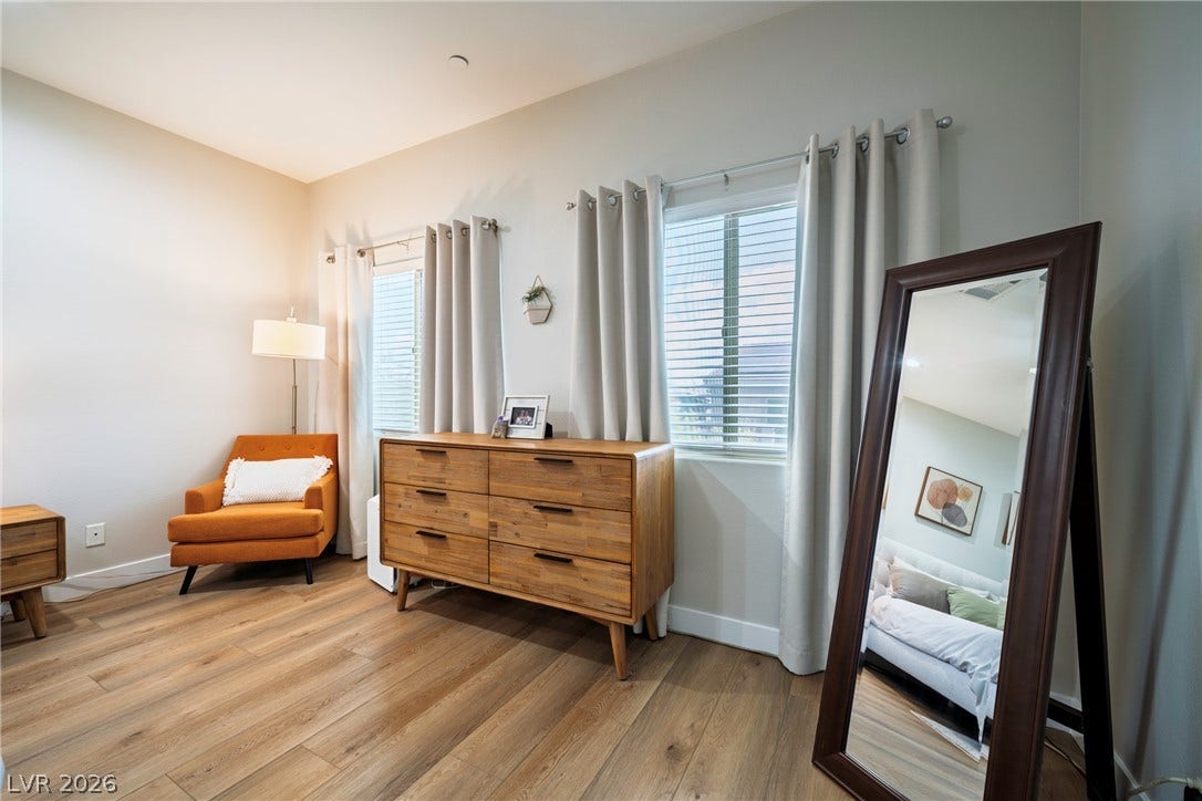 152 Dunblane Street, Henderson, NV 89012 Warm wood-toned floors and multiple windows create a comfortable, well-lit bedroom atmosphere.