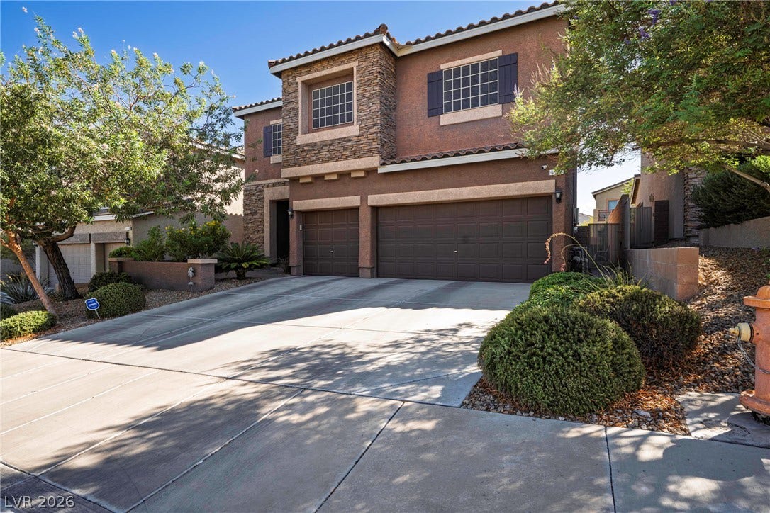 152 Dunblane Street, Henderson, NV 89012 A spacious driveway leads to this multi-car garage beneath a handsome stone-accented facade.