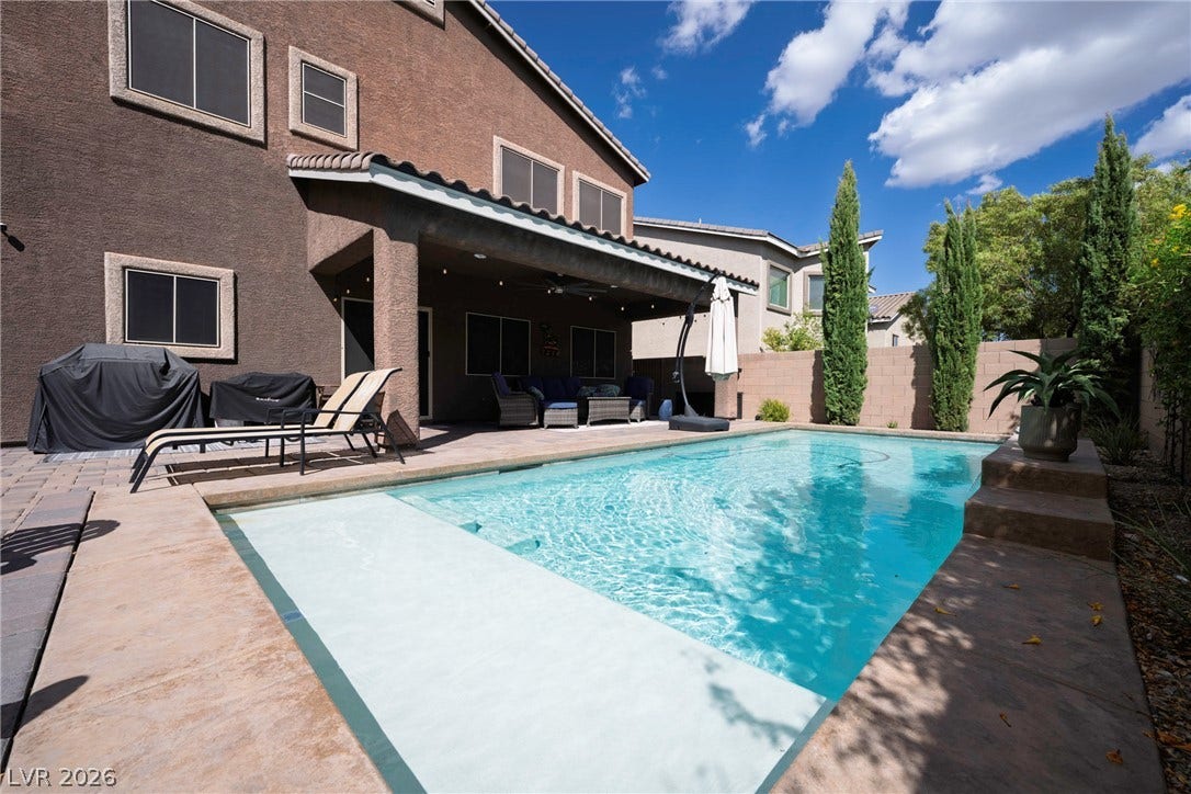 152 Dunblane Street, Henderson, NV 89012 An inviting backyard oasis features a pristine swimming pool and a covered patio area.