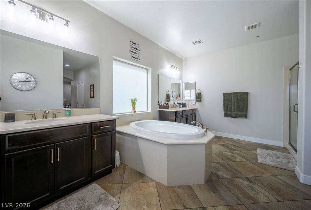 152 Dunblane Street, Henderson, NV 89012 An deep soaking tub anchors this main bath featuring wood-look tile flooring.