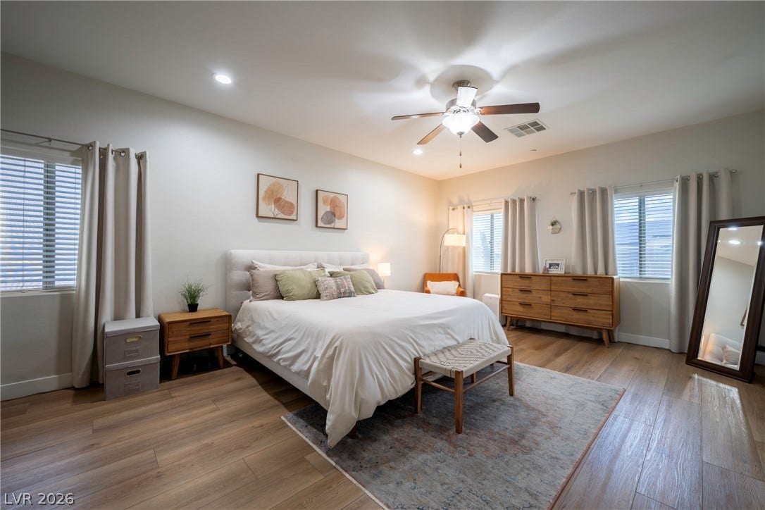 152 Dunblane Street, Henderson, NV 89012 Warm wood-style flooring and generous windows anchor this peaceful, light-filled bedroom suite.