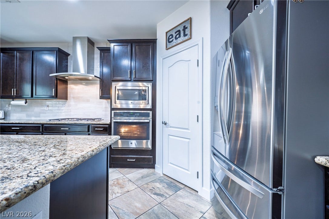 152 Dunblane Street, Henderson, NV 89012 Rich dark cabinetry pairs beautifully with stone countertops and stainless steel appliances.