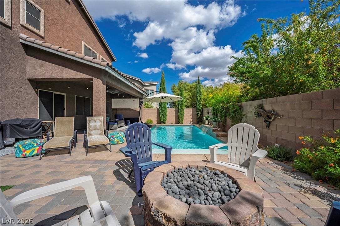 152 Dunblane Street, Henderson, NV 89012 An inviting backyard oasis features a paved patio, built-in fire pit, and private swimming pool.