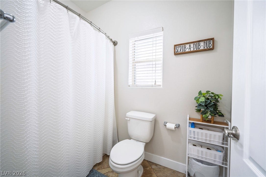 152 Dunblane Street, Henderson, NV 89012 Natural light from a classic window illuminates this tidy bathroom featuring textured tile flooring.