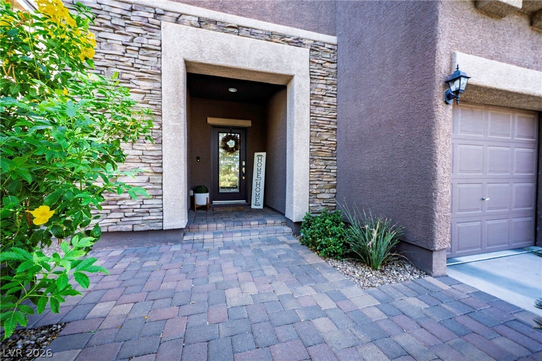 152 Dunblane Street, Henderson, NV 89012 Stacked stone accents frame a welcoming recessed entryway paved with classic interlocking stones.