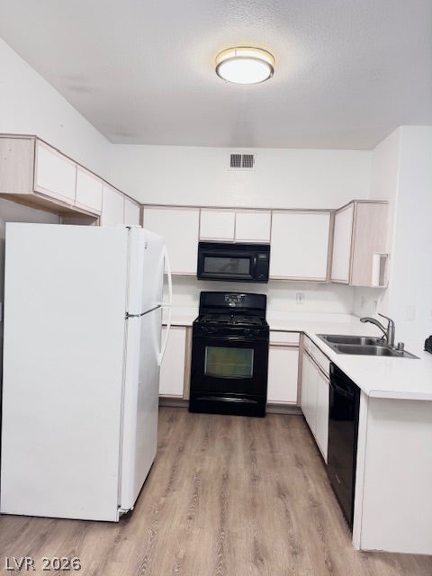 Streamlined cabinetry and hard surface flooring define this functional u-shaped kitchen workspace.